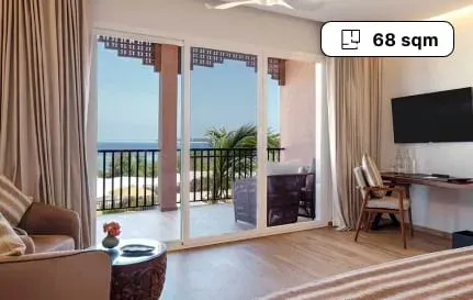 Superior Suite bedroom with ocean-view balcony at The Mora Zanzibar