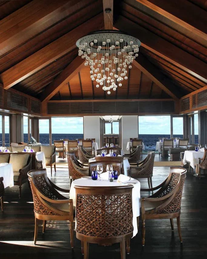 The Falhumaa overwater fine-dining room with chandelier and ocean view, The Residence Maldives at Falhumaafushi
