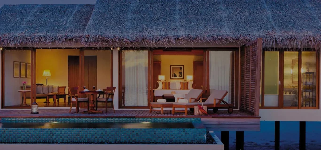 Deluxe Water Pool Villa exterior over the lagoon at dusk, The Residence Maldives at Falhumaafushi