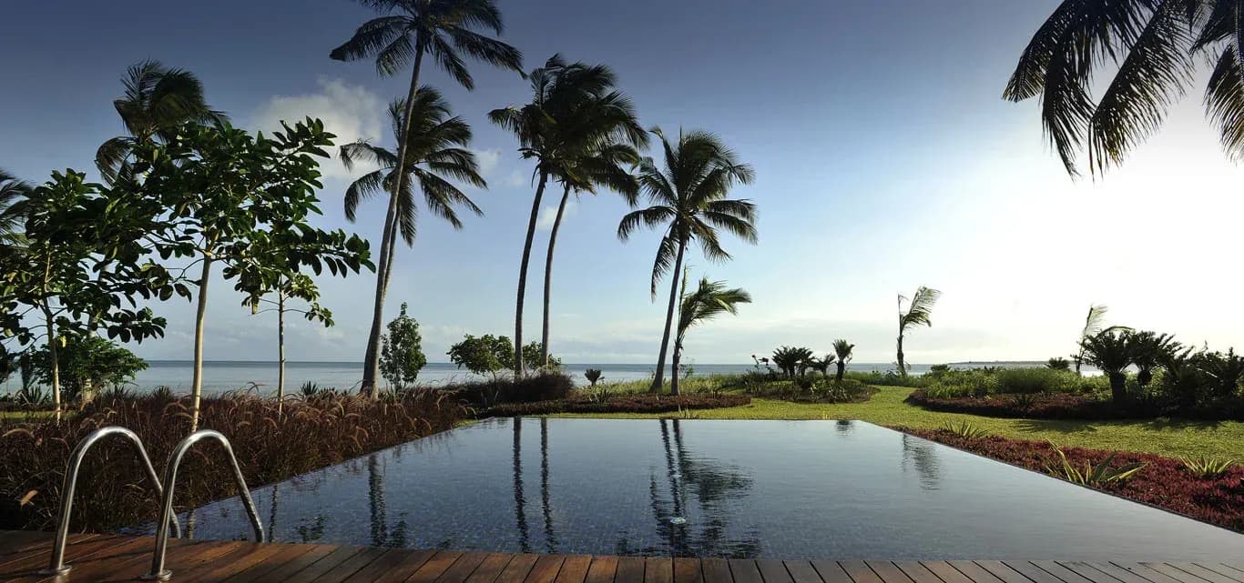 Presidential Pool Villa private swimming pool framed by palm trees at The Residence Zanzibar