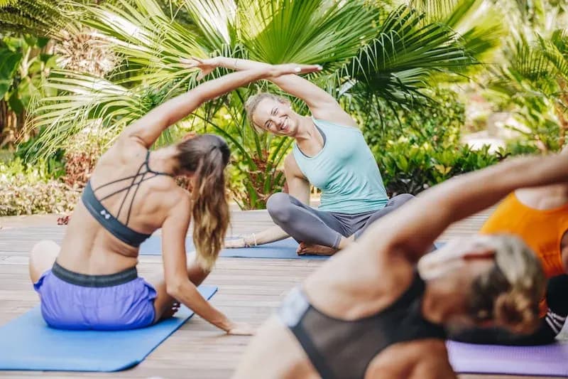 Guests stretching during a yoga session in the gardens at Tulia Zanzibar