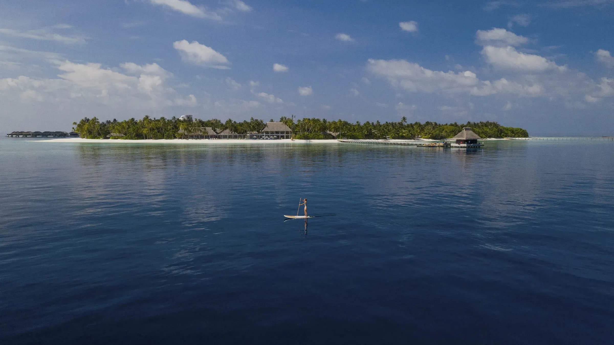 Aerial view of Velaa Private Island's beach, jetty and overwater villas, Noonu Atoll, Maldives
