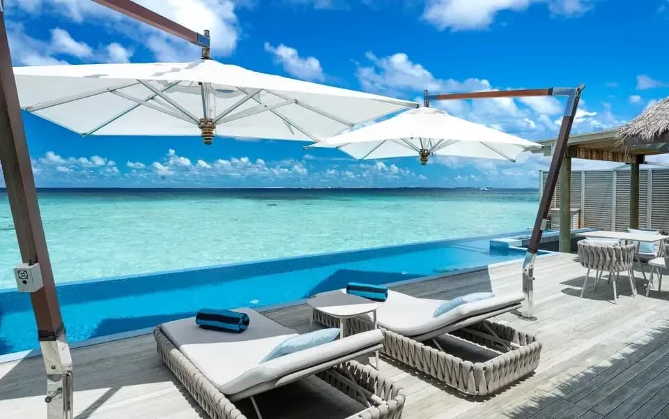 Water Suite private deck with sun lounges over the ocean at Niva Velassaru Maldives