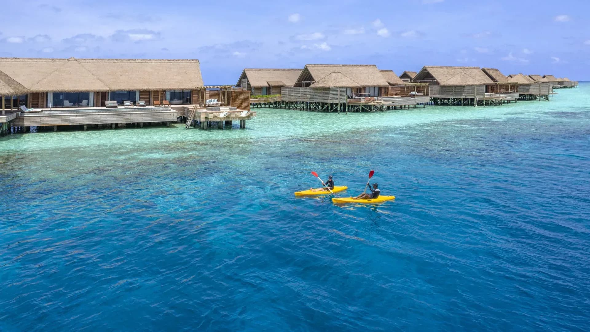 Kayaks in the lagoon with overwater villas beyond, Waldorf Astoria Maldives Ithaafushi