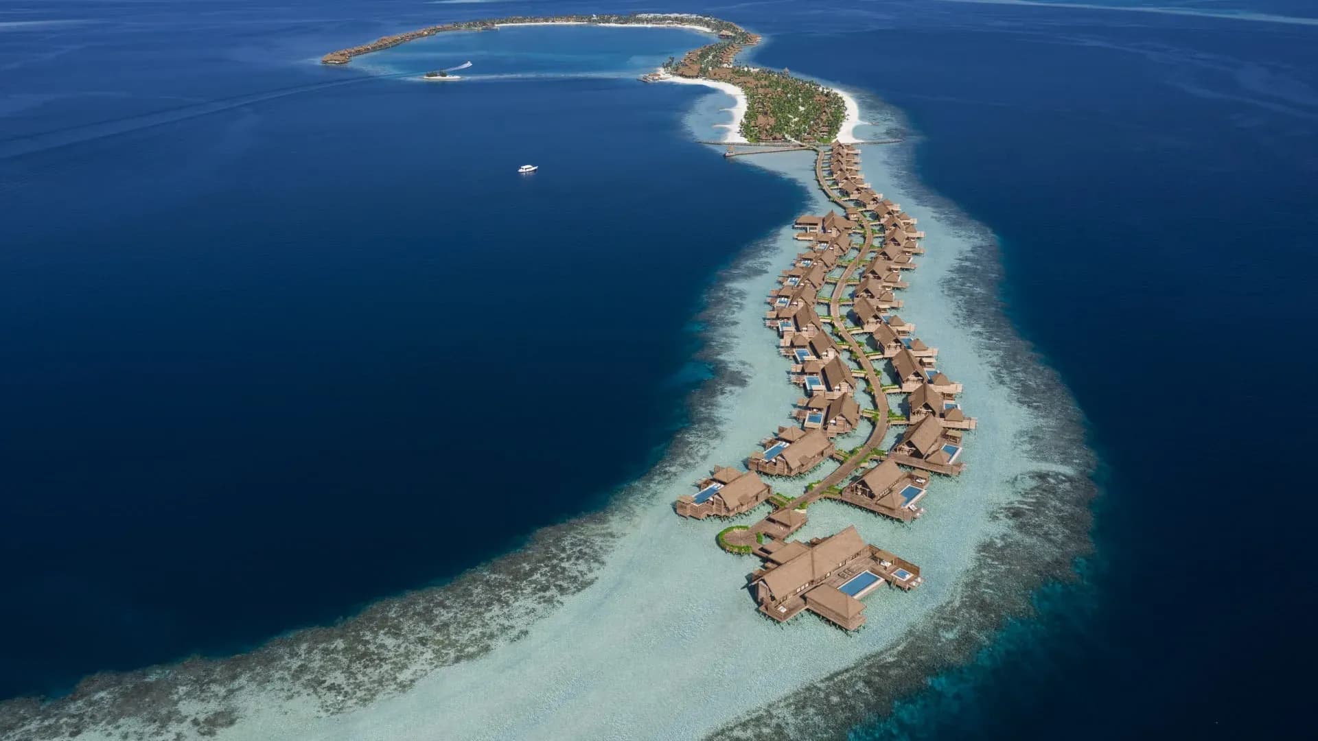Aerial overview of the resort's beach, lagoon and overwater villas at Waldorf Astoria Maldives Ithaafushi