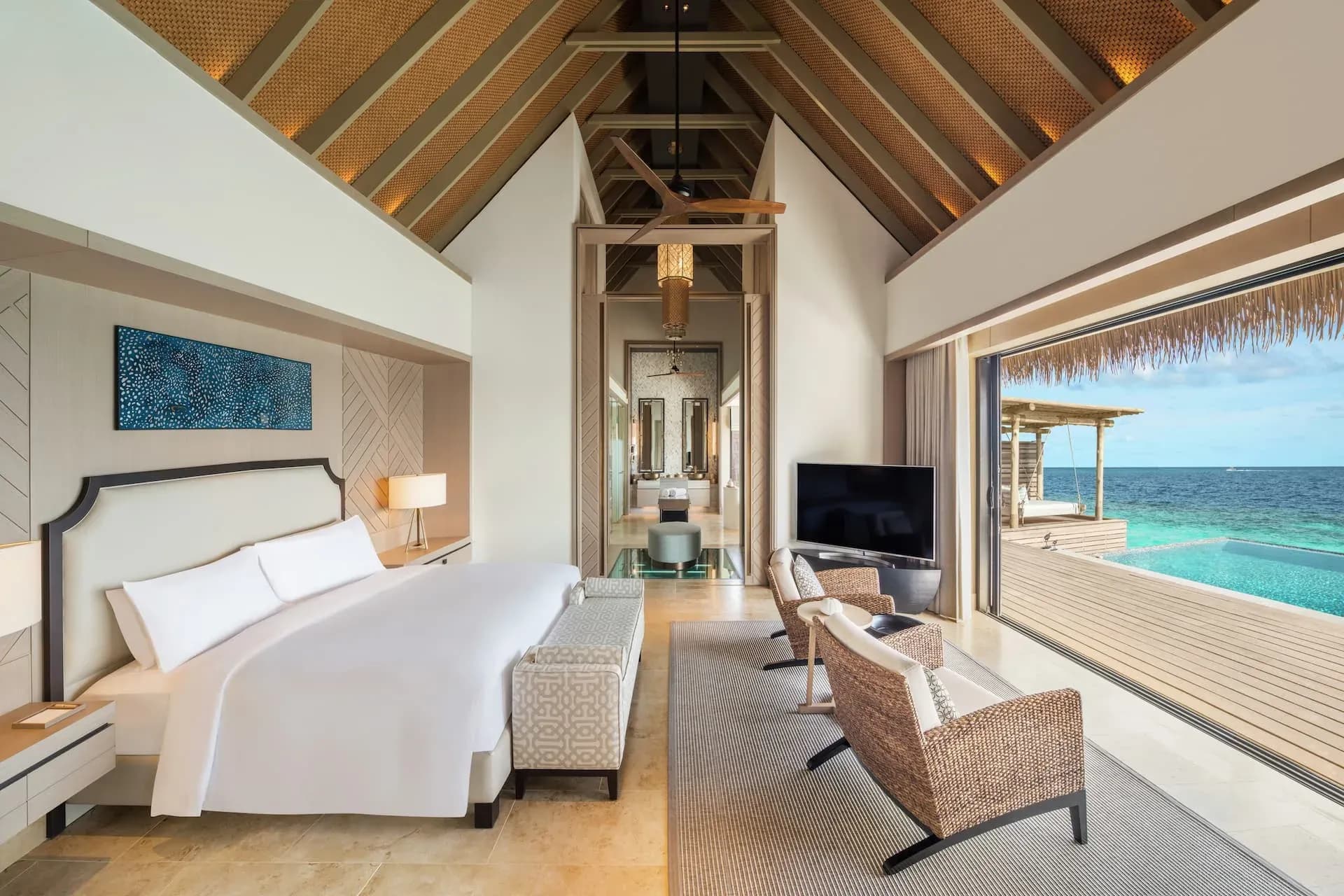 King Overwater Villa bedroom with floor-to-ceiling ocean views at Waldorf Astoria Maldives Ithaafushi