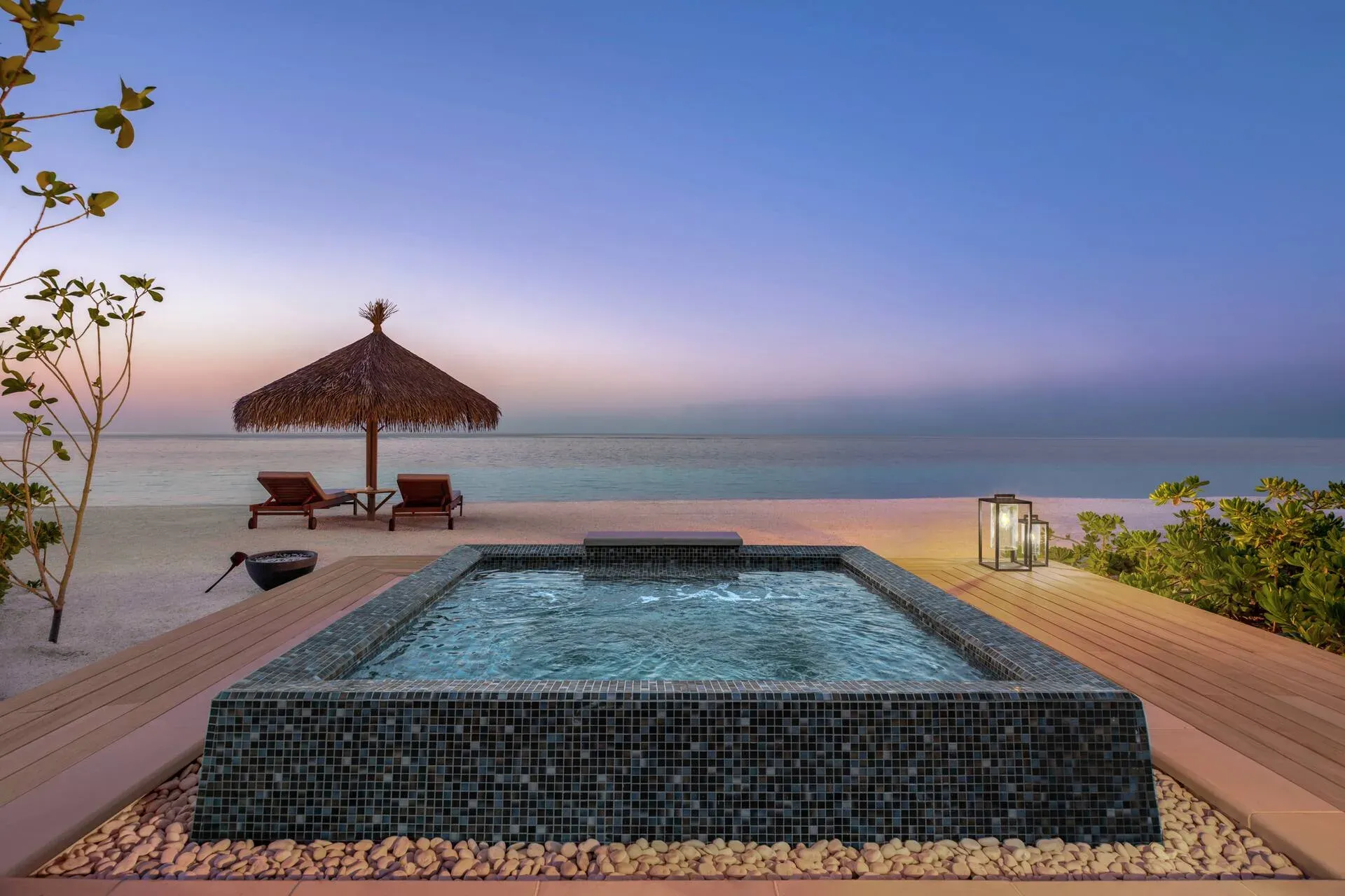 Outdoor jacuzzi and sun loungers at a Two Bedroom Grand Beach Villa, Waldorf Astoria Maldives Ithaafushi
