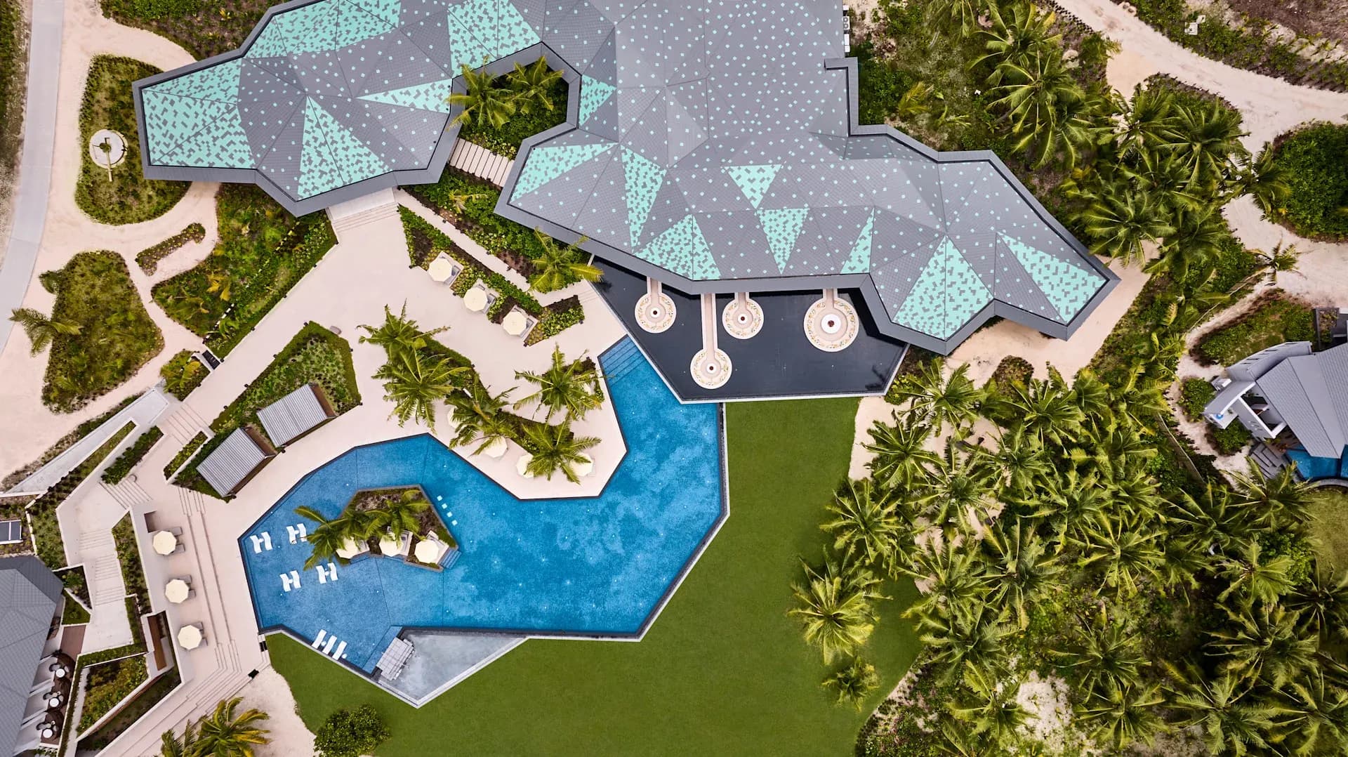 Aerial view of a beachfront pool villa complex resembling the Five Bedroom Eagle Ray Pool Villa